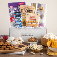 Thumbnail for Open gift basket labeled ‘Celebrate & Elevate’ with popcorn, cookies, vegetable chips, and savory snacks.