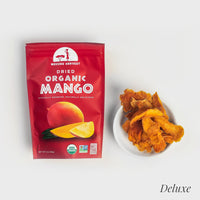 Thumbnail for Package of Mavuno Harvest dried organic mango next to a small white bowl filled with dried mango slices