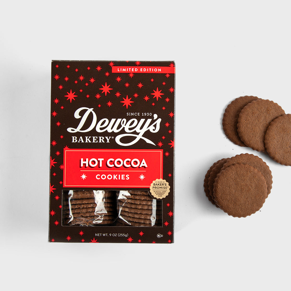 Dewey’s Bakery Hot Cocoa Cookies in festive limited edition packaging, with rich chocolate cookies displayed