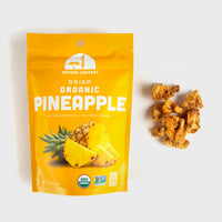 Thumbnail for Mavuno Harvest Dried Organic Pineapple in a bright yellow resealable pouch, shown with dried pineapple chunks