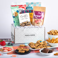 Thumbnail for Open gift basket labeled ‘Make Them Smile’ with cookies, chocolate, sour gummies, and crunchy pretzels.