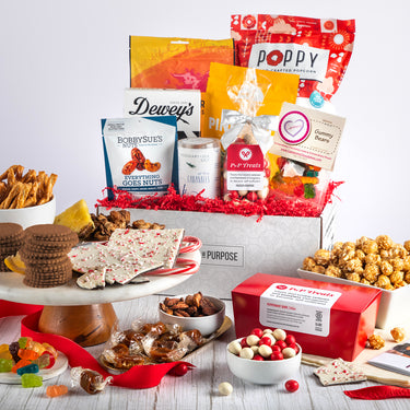 Open gift basket holiday edition labeled ‘Something for Everyone’ with cookies, caramels, popcorn, pretzels, and dried fruit.