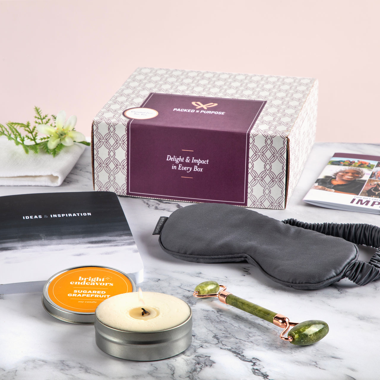 Spa and Self Care Package featuring a candle, jade facial roller, black sleep mask, and journal.