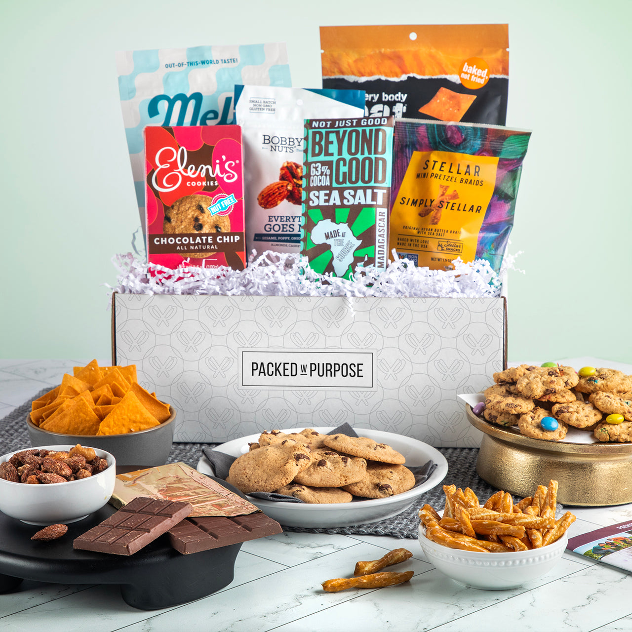 Open gift basket labeled ‘Thoughtful Wishes’ with cookies, handcrafted chocolate, gourmet nuts, and dried fruit.